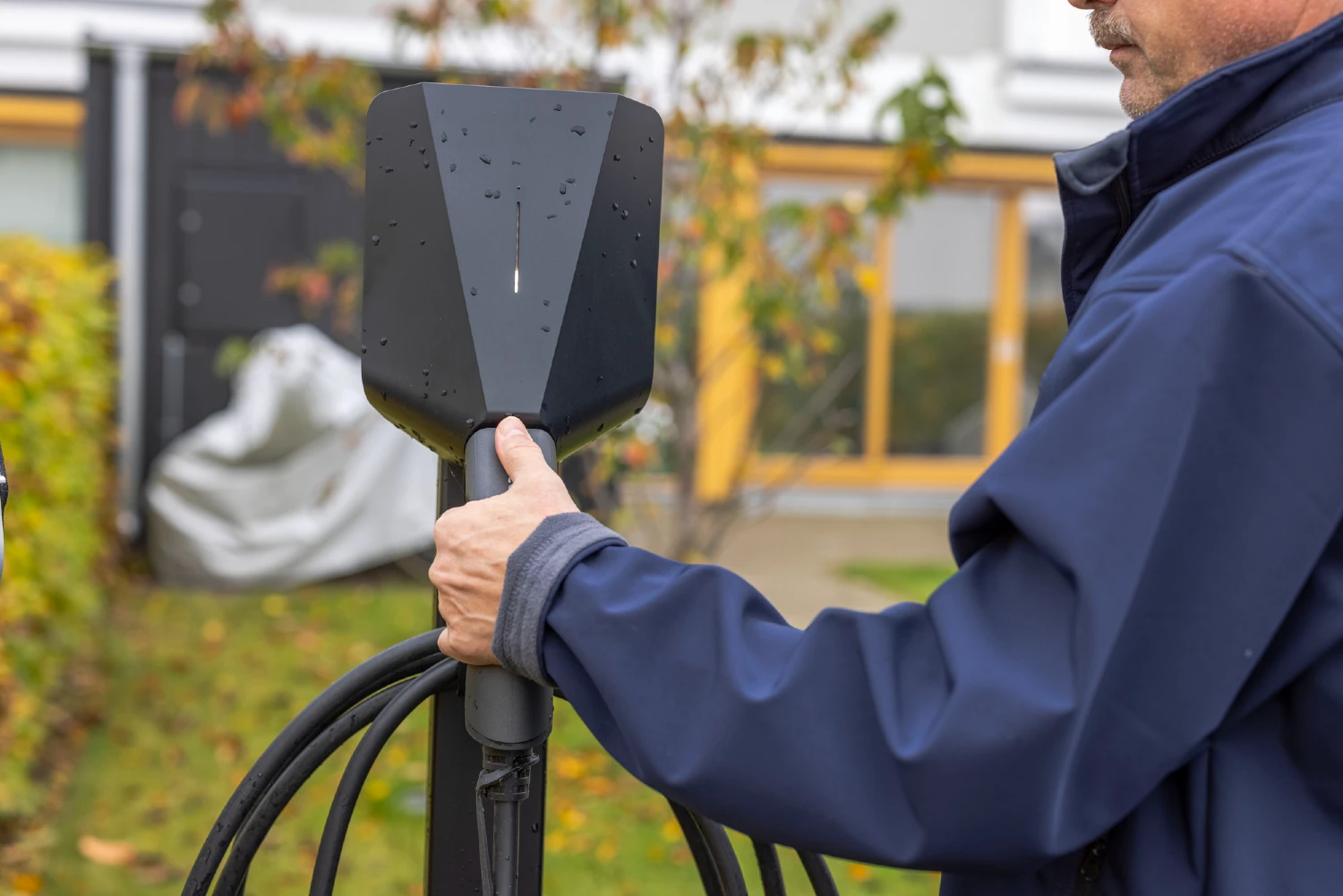 Mand tager fat i ladekabel fra ladeboks